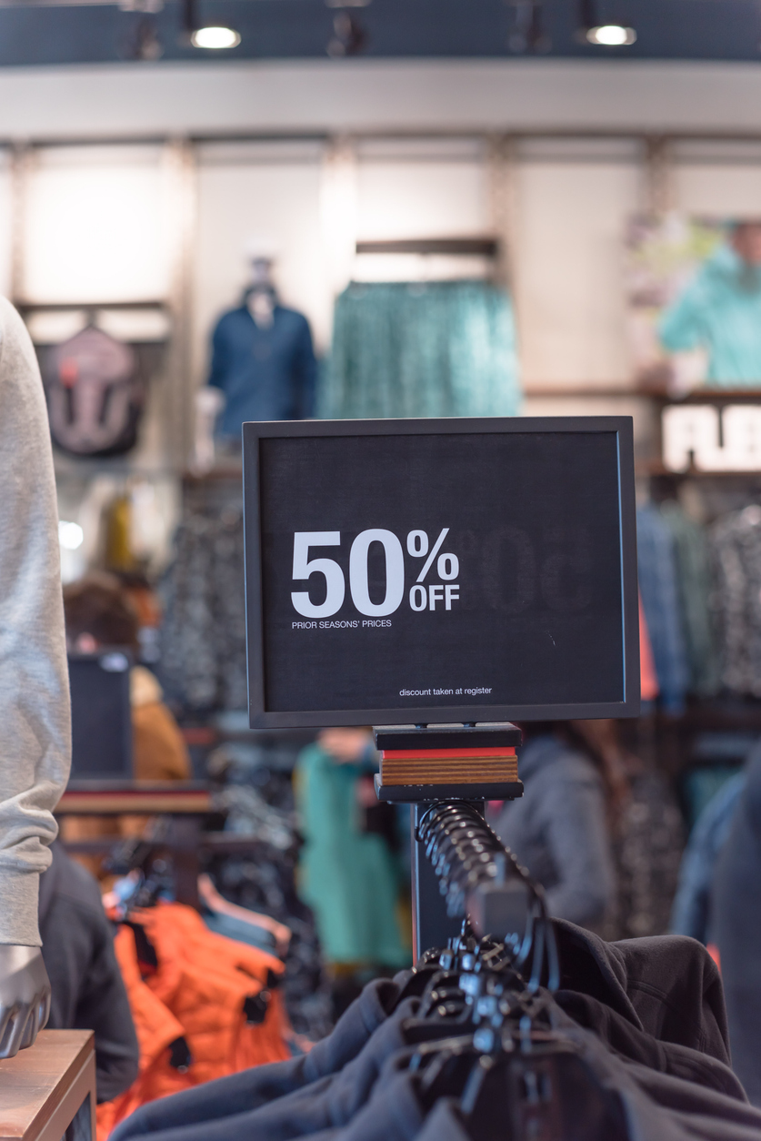 Close-up 50 percent off sale sign over clothes at department store in Texas, America